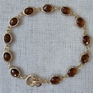 Elegant bracelet, brown faceted crystal charms in gold plated frames. 7.75”.